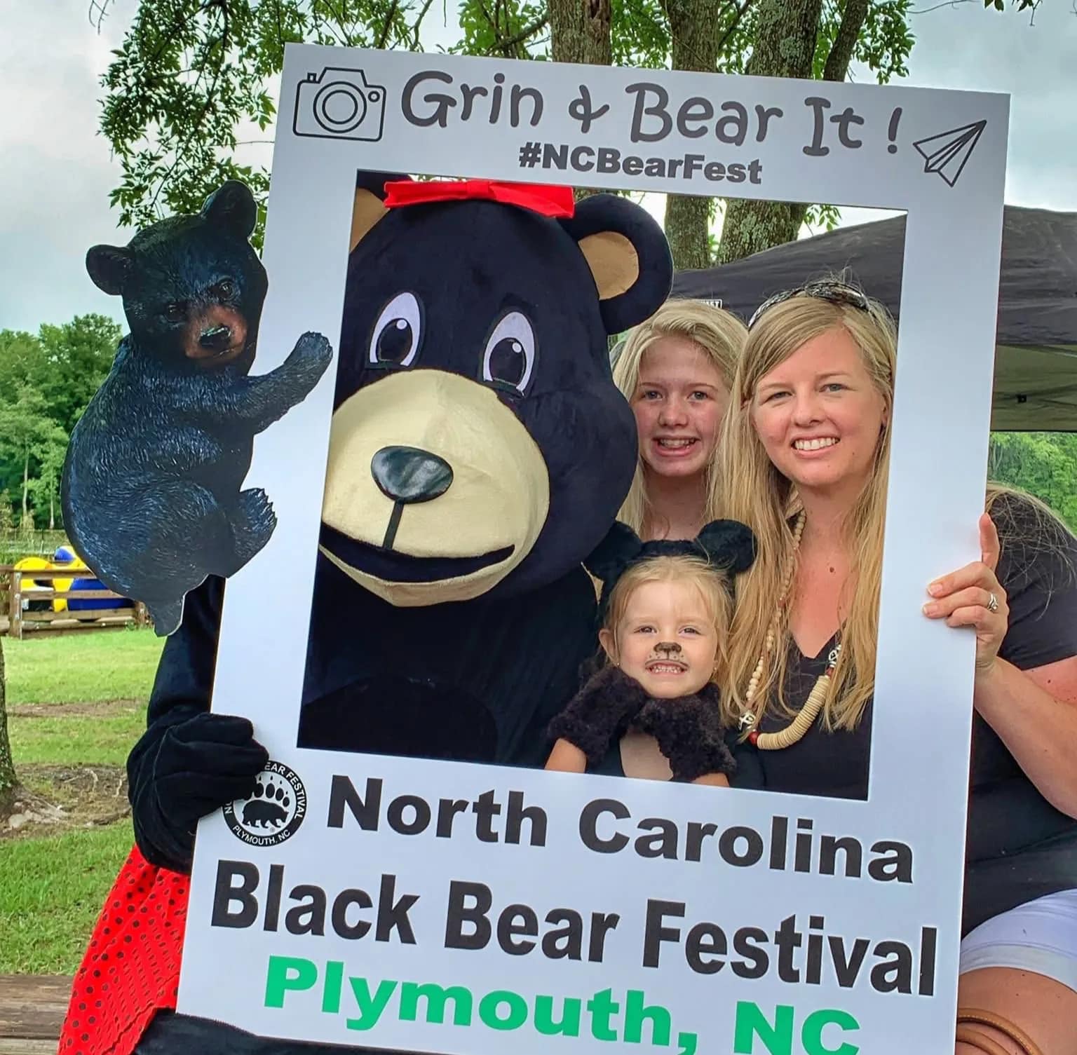 community-1 A family poses with a bear mascot in a festival photo frame at the North Carolina Black Bear Festival.